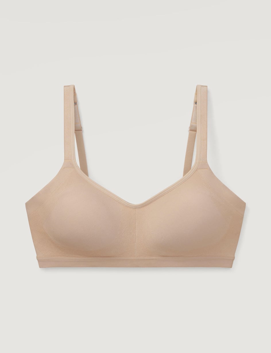 Beige seamless bra photographed flat on a light grey background
