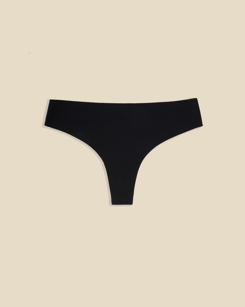 Black seamless thong photographed flat on a cream background
